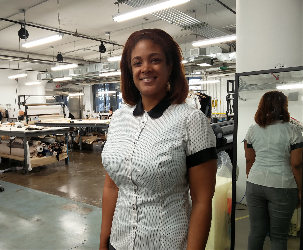 Kristen, founder of Exclusively Kristen, on her manufacturer's factory floor wearing a sample of the polka dot shirt