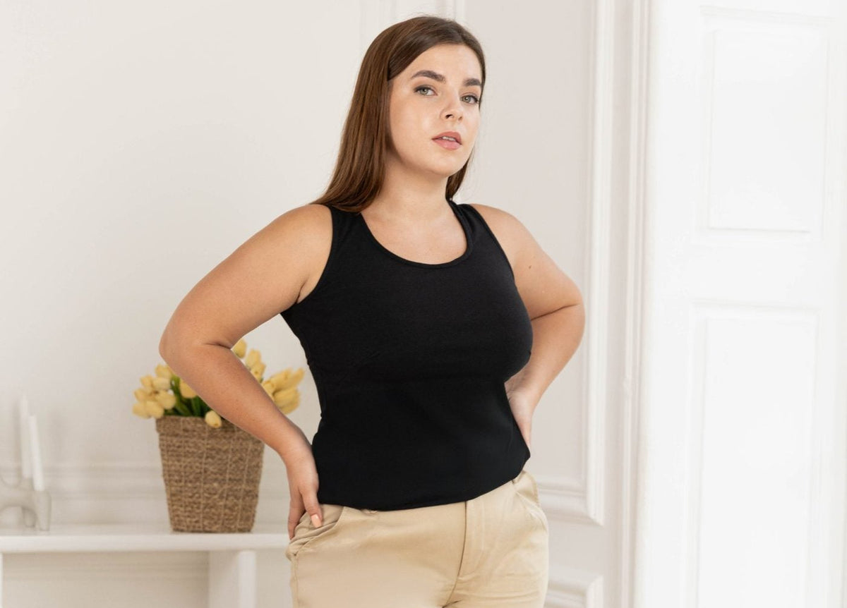 Model wearing the Full Coverage Black Tank Top with tan wide-leg trousers, designed for a fuller bust | Exclusively Kristen